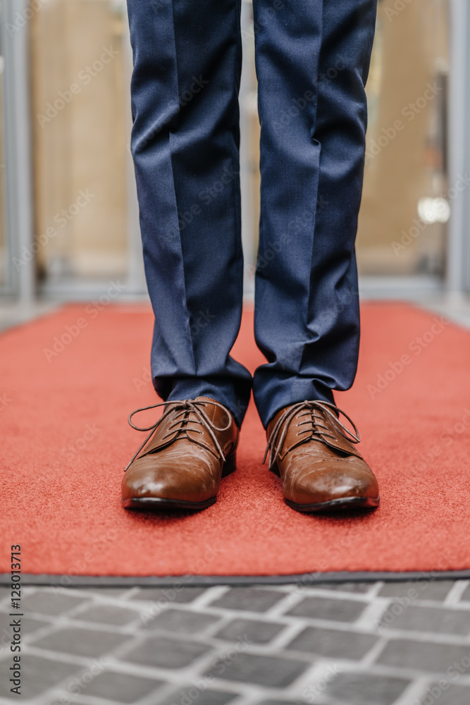 Businessman standing on red carpet, partial view Businessman standing on red carpet, partial view