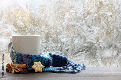 warming drink on a winter day/ large white mug with blue scarf standing on a table with cinnamon and ginger cookies 