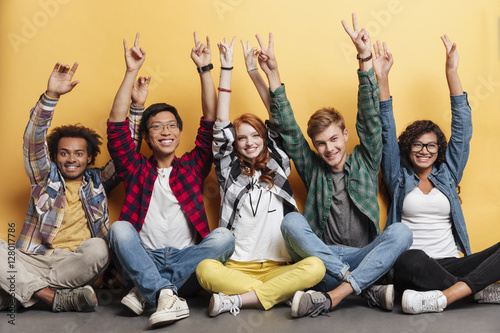 People celebrating success and showing peace sign with raised hands