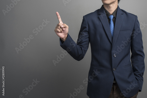 Close up of businessman in blue suit touching on gray background