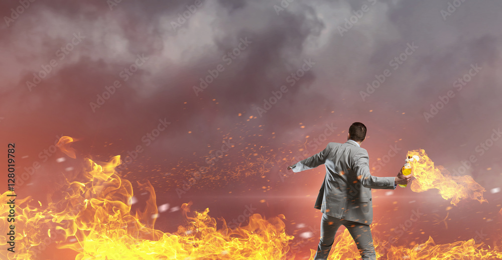 Obraz premium Businessman throwing petrol bomb . Mixed media