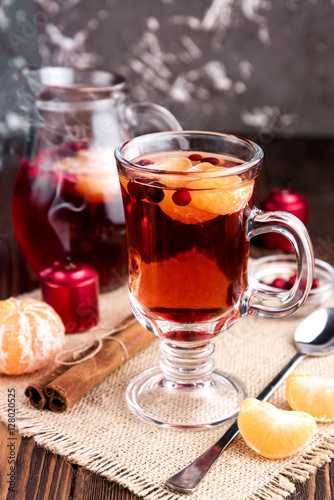 Mulled wine in a glass on wooden background