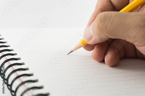 Hands of man writing with a pencil in notebook