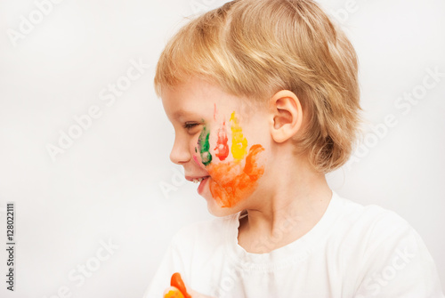  Profile portrait of funny child with colorful hand prints on cheeks.