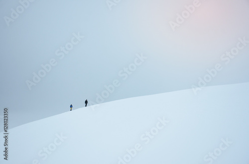 Two tourist walking in snowy landscape in norway. They travel to famous trolltunga rock