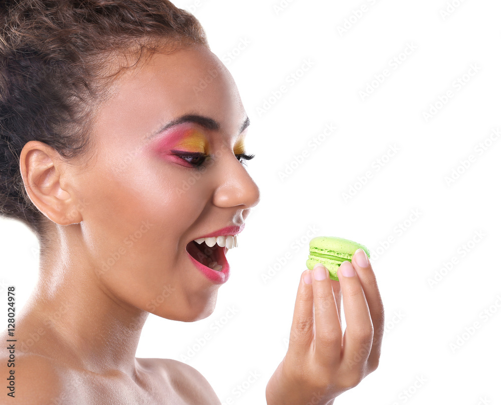 Young woman eating delicious macaroon on white background Young woman eating delicious macaroon on white background
