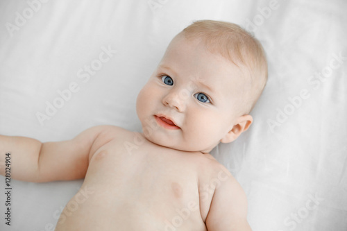 Portrait of little baby on white bed