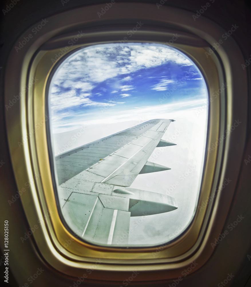 Clouds and sky as seen through window of an aircraft Clouds and sky as seen through window of an aircraft