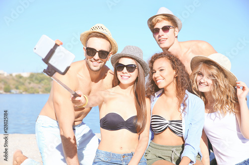 Happy friends taking selfie on beach