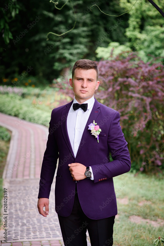 handsome and young groom in blue suit standing outdoors handsome and young groom in blue suit standing outdoors