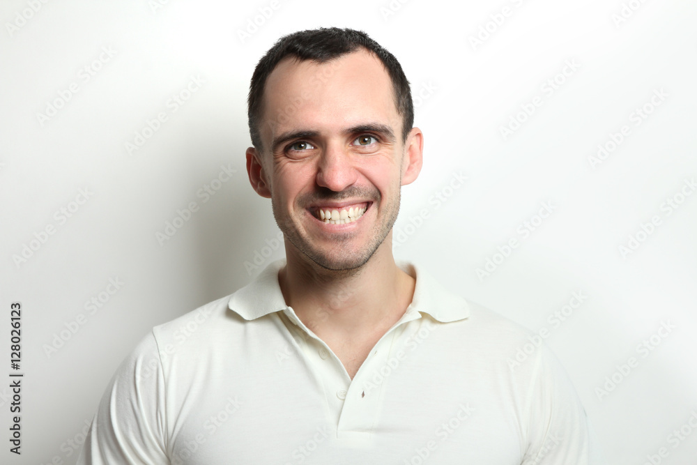Portrait of a happy young man on a light background.
