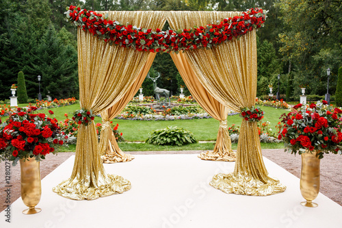 Red flower garland put on golden wedding altar photo