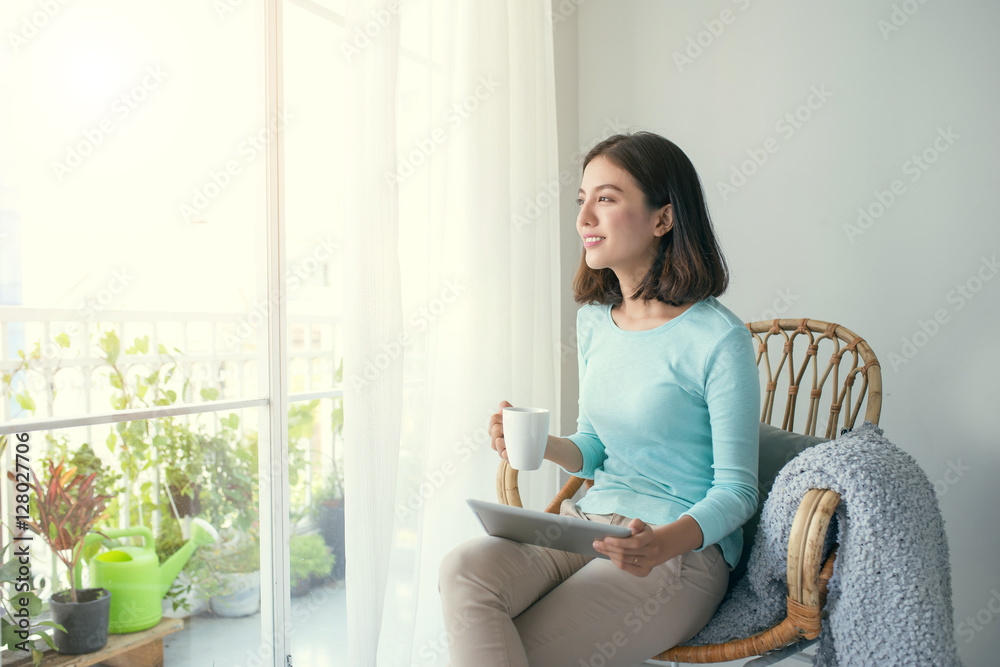 Beautiful asian young woman relaxing and using digital tablet at Beautiful asian young woman relaxing and using digital tablet at