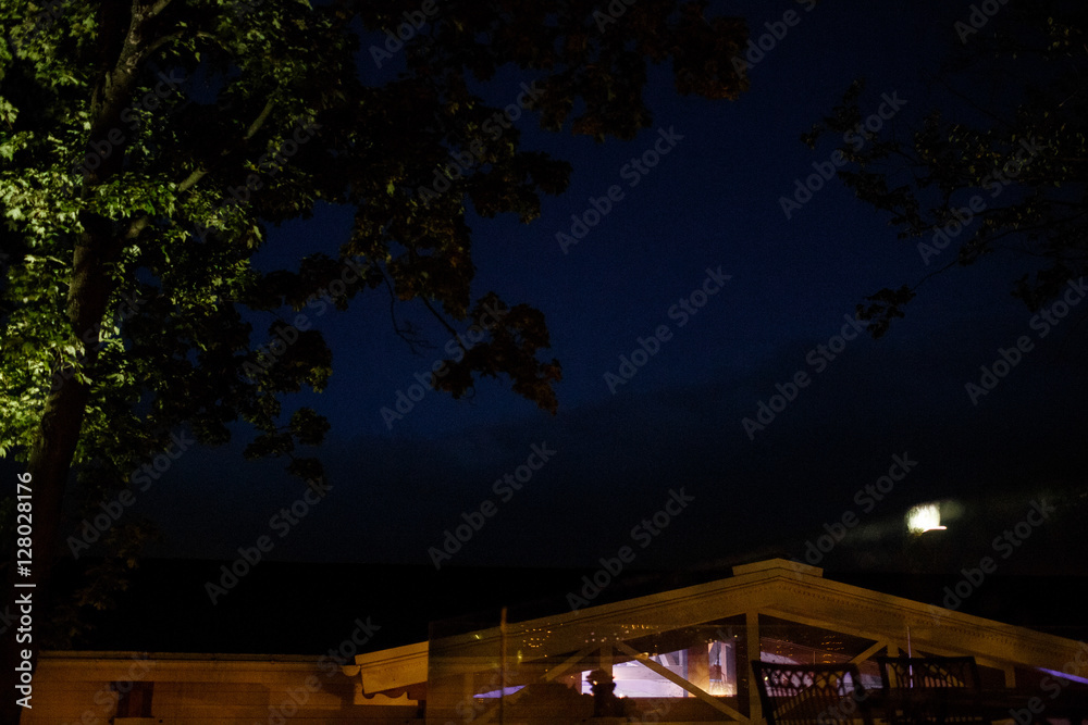 Fototapeta premium Moon shines over wooden house