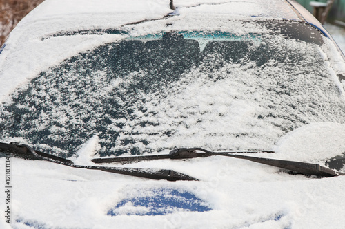 Car windshield covered with snow