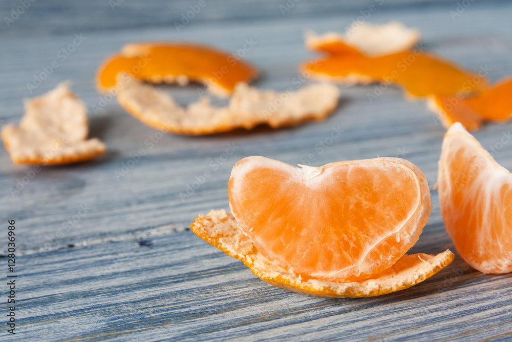 Tangerine slice and zest on wooden background