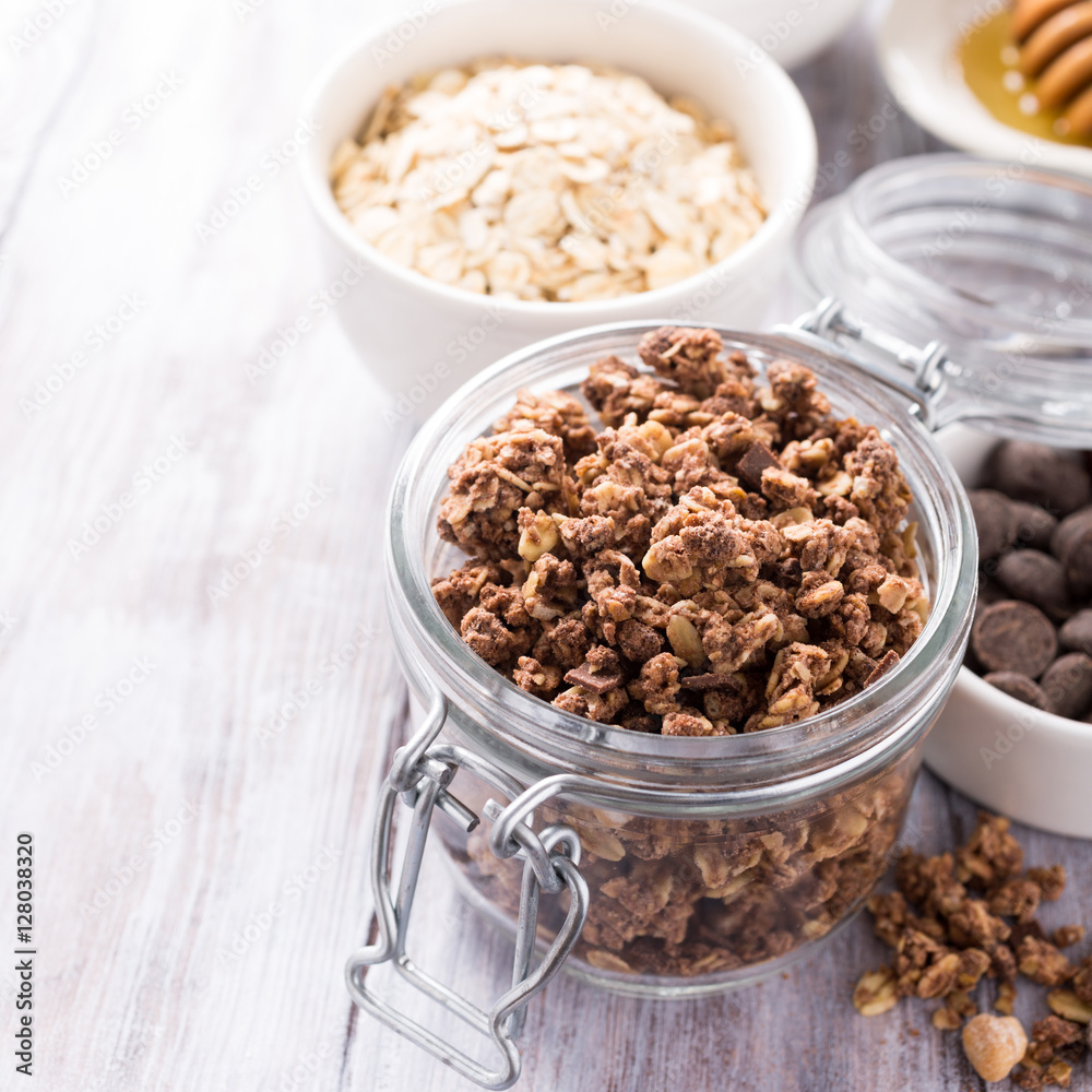 Homemade chocolate granola ingredients, nuts, oats, honey on white wooden background. Healthy brakfast concept with copy space. Homemade chocolate granola ingredients, nuts, oats, honey on white wooden background. Healthy brakfast concept with copy space.