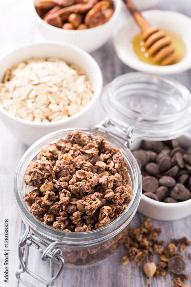 Homemade chocolate granola ingredients, nuts, oats, honey on white wooden background. Healthy brakfast concept. Homemade chocolate granola ingredients, nuts, oats, honey on white wooden background. Healthy brakfast concept.