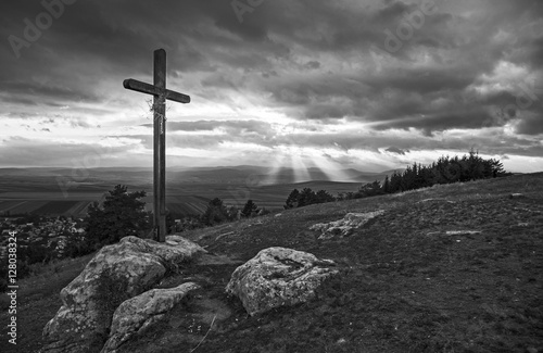 Wooden cross on hill in black and white