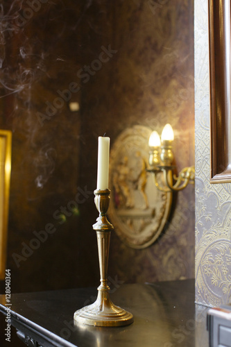 A golden coloured candleholder in a traditional Dutch interior.