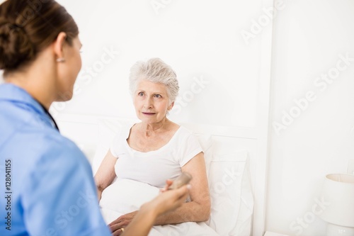 Nurse taking care of suffering senior patient 