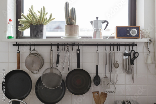 detail of a modern kitchen with pans and such hanging on a wall