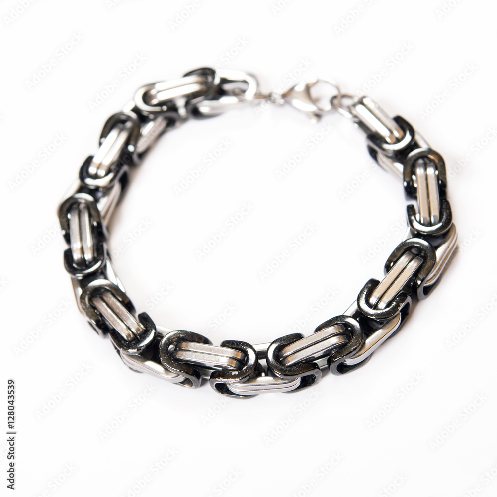 Fototapeta premium Iron men's bracelet with black inserts is isolated on a white background