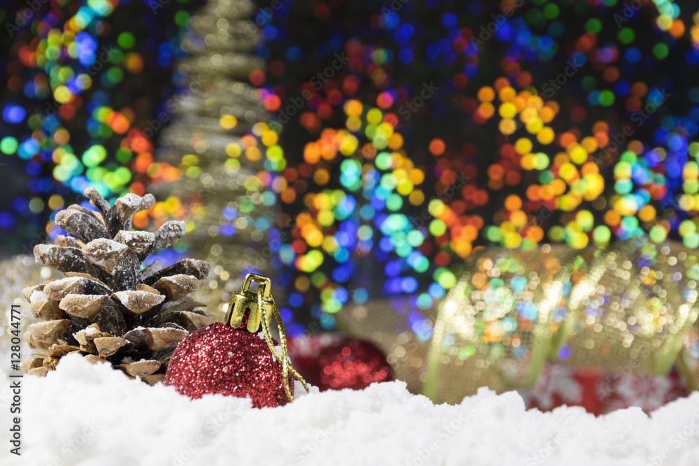 Pines, baubles and Christmas gifts on snow with shiny, glittering background 