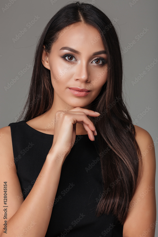 Close up portrait a brunette woman in black dress posing