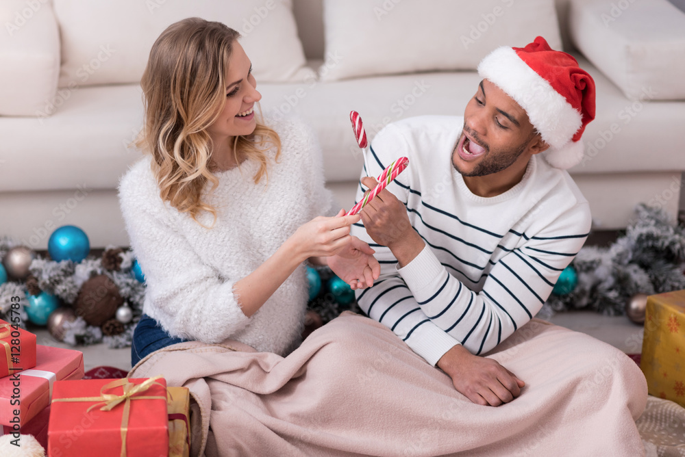 Fototapeta premium Happy nice couple exchanging lollipops