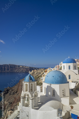 Scenic view of traditional cycladic white houses and blue domes in Oia village  Santorini island  Greece