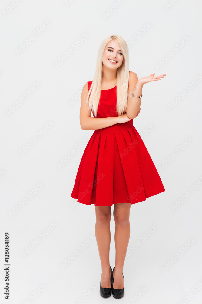 Smiling woman in red dress holding copyspace on the palm Smiling woman in red dress holding copyspace on the palm