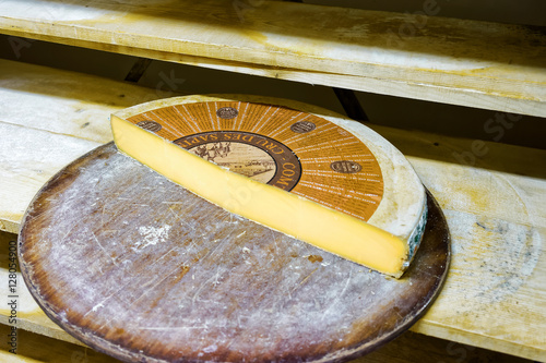 Slice of the Aging Gruyere de Cheese on wooden shelves