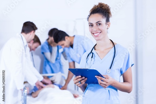Female doctor holding clipboard and smiling at camera