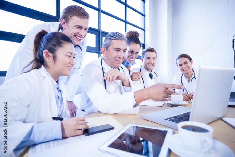 Medical team looking into laptop and having a discussion