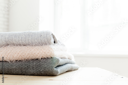 Stack of white cozy knitted sweaters © fotofabrika