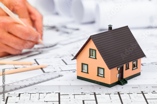 Construction plans with drawing tools and House Miniature on blu