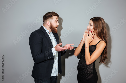 Young attractive couple in smart clothes having conversaion photo