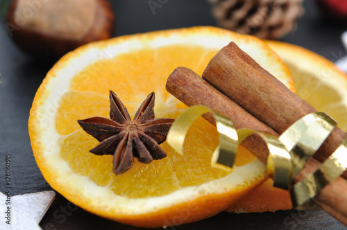 anis sur orange coupée et bâtons de cannelle liés par ruban doré