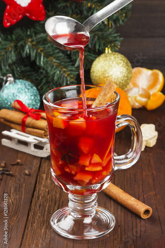 Mulled wine with citrus in glass on a dark wooden background