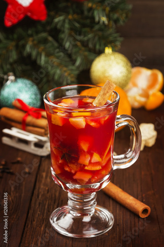 Mulled wine with citrus in glass on a dark wooden background. To