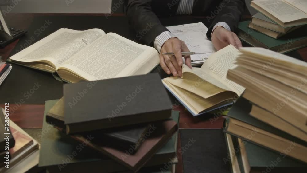 Businessman working and exploring books in the working room. Shot on RED EPIC Cinema Camera.