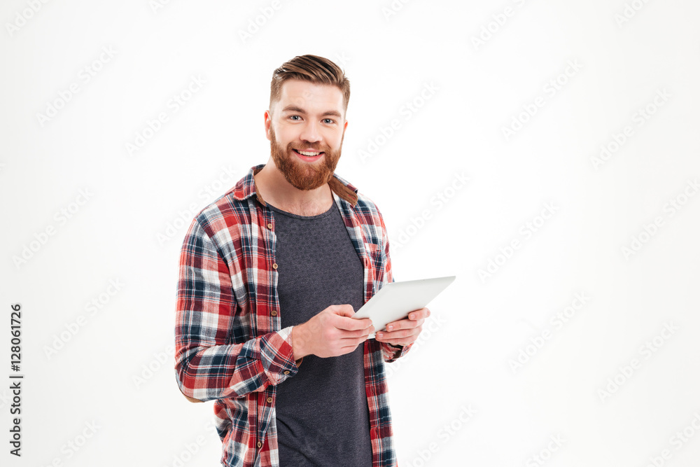 Smiling casual man holding tablet computer and looking at camera Smiling casual man holding tablet computer and looking at camera