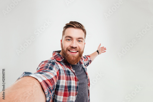 Close up portrait of a cheerful bearded man taking selfie photo