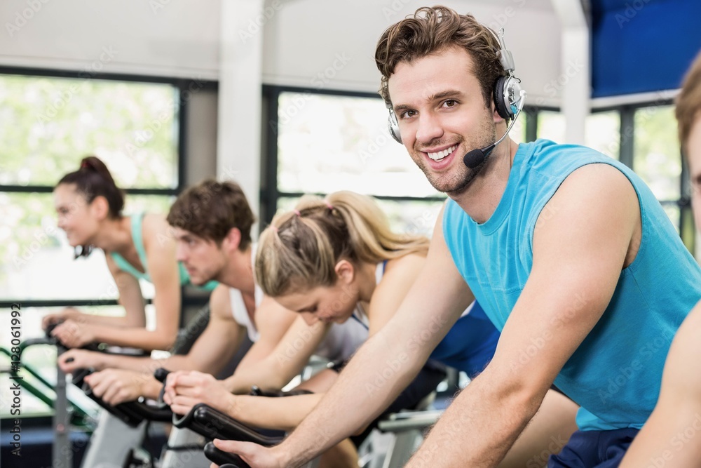 Obraz premium Fit group of people using exercise bike together