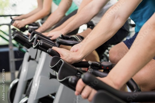Fit group of people using exercise bike together © WavebreakMediaMicro