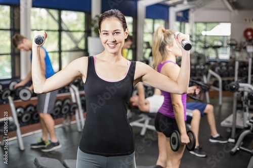 Smiling woman working out with dumbbells