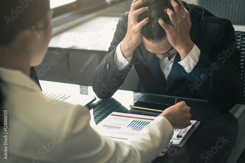 Boss scolding a shameful employee at work in an office. Businessman with sad expression working with boss.Worried businessman working trying to solve troubles.