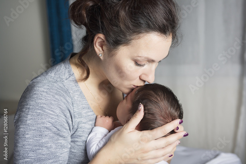 Happy mother holding adorable child baby on the living room