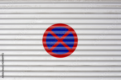 Closed garage entrance door with forbidden parking sign on outsi photo